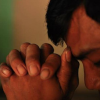 Man praying with clasped hands